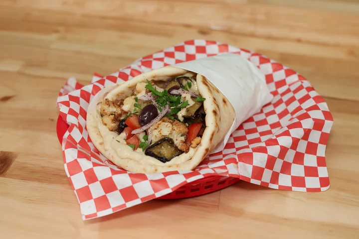 Cauliflower and eggplant gyro with hummus, tomatoes, olives and tahini.
