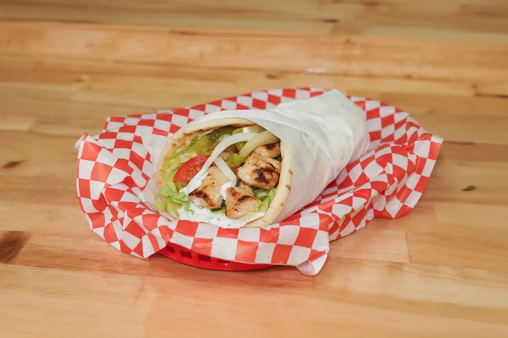 Grilled chicken souvlaki gyro with vegetables and tzatziki.