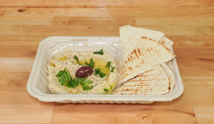 Creamy hummus with olive oil and grilled pita wedges.