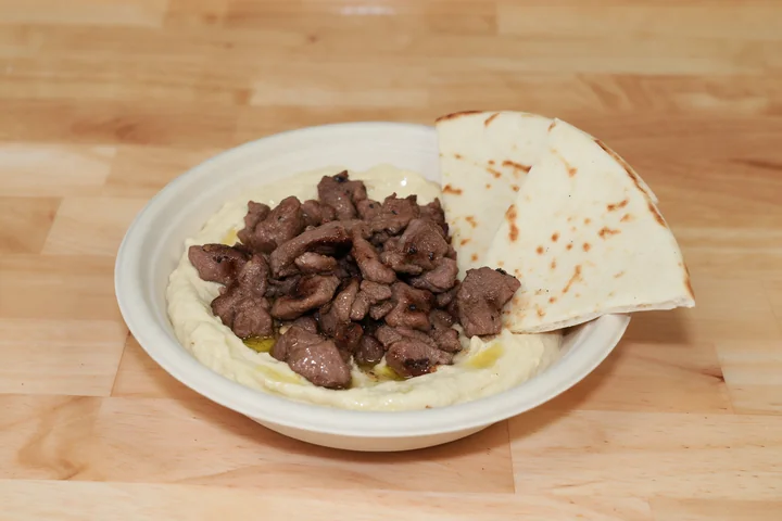Seared lamb over creamy hummus with warm pita wedges.