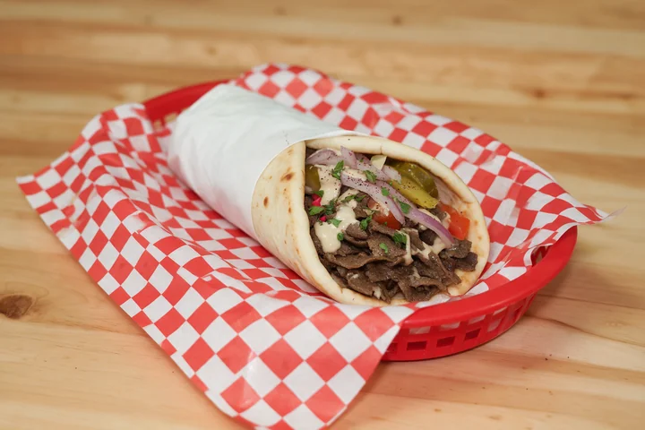 Beef shawarma pita wrap with onions, pickles, tomatoes and tahini.