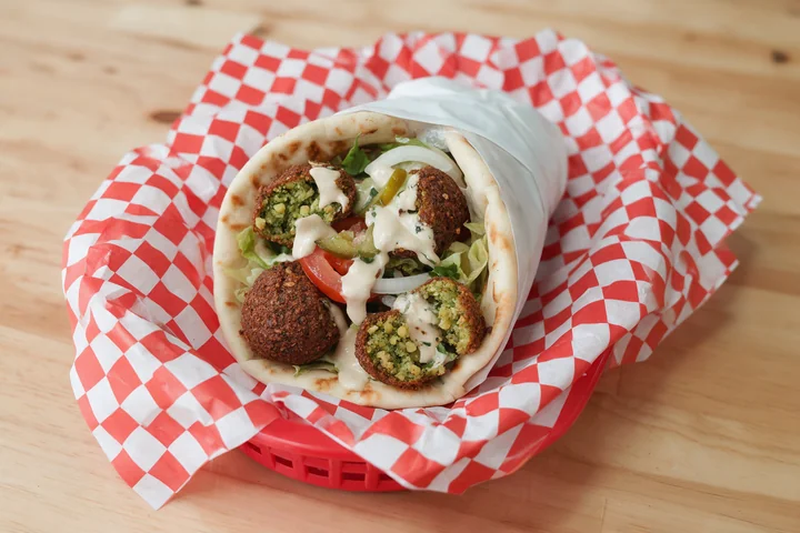Crispy falafel gyro with vegetables and tahini in pita.