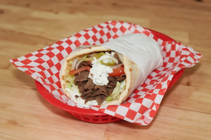Beef and lamb gyro with vegetables and tzatziki in pita.